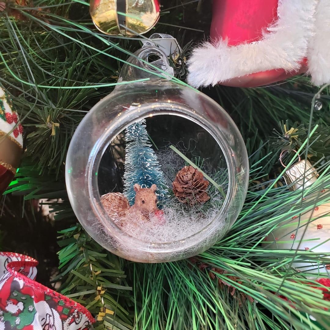 Globo de vidrio con una escena de bosque en miniatura